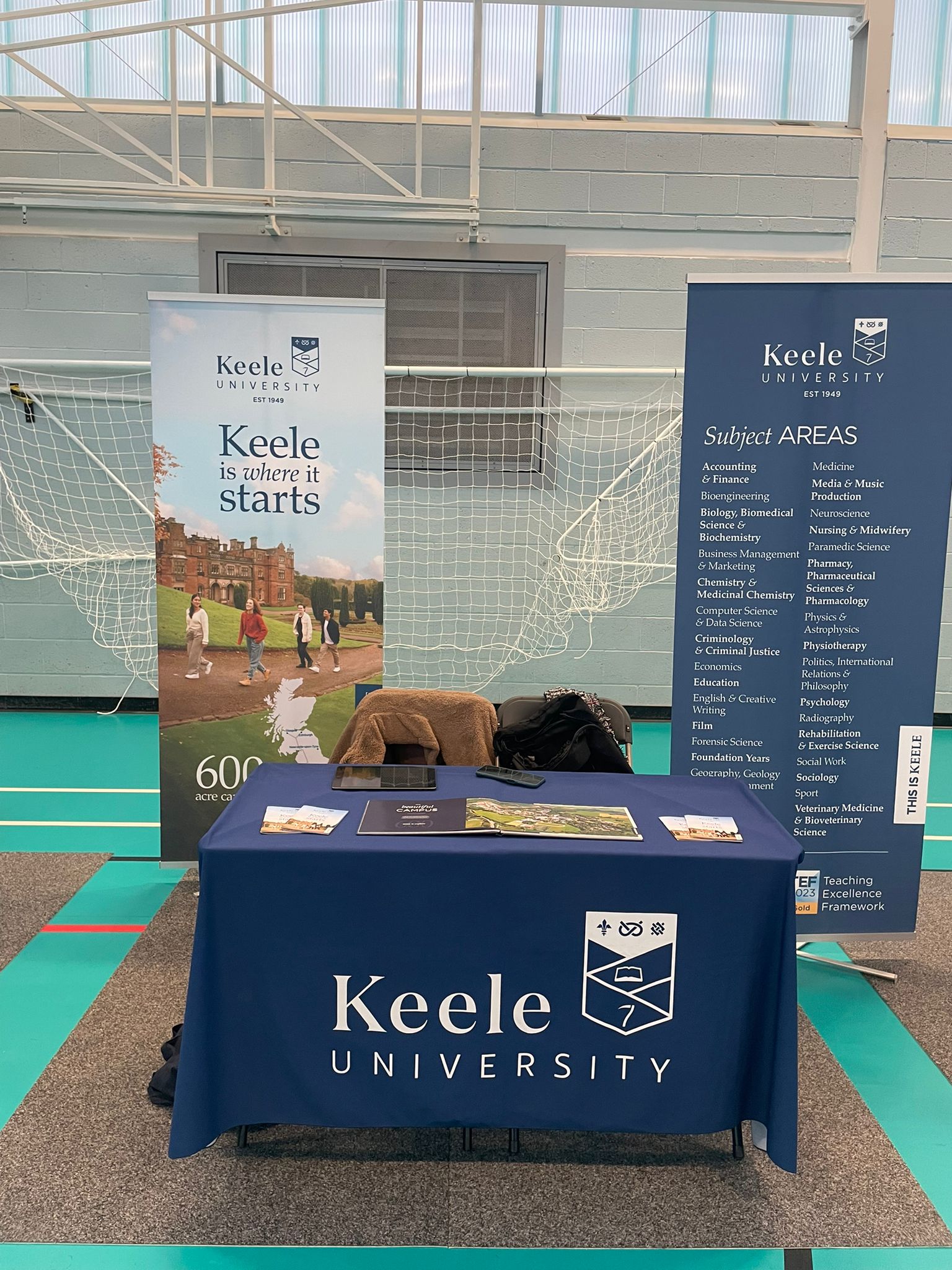 two banners and a stand at a student recruitment event